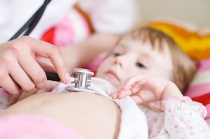 Pediatric doctor exams little girl with stethoscope