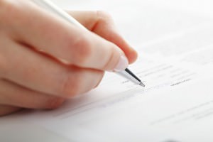 Businesswoman writing on a form