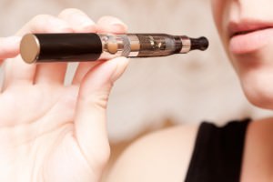 Close up of a woman inhaling from an electronic cigarette